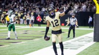 New Orleans Saints wide receiver Chris Olave (12) waves to fans after scoring a touchdown against New York Jets cornerback Brandon Stephens (21) during the second half at Caesars Superdome.