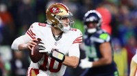 San Francisco 49ers quarterback Mac Jones (10) rolls out against the Seattle Seahawks during the second half in an NFC Divisional Round game at Lumen Field.
