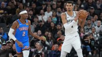 Spurs center Victor Wembanyama (1) looks down the court beside Oklahoma City Thunder guard Shai Gilgeous-Alexander (2) in the first half at Frost Bank Center with Pacers' Tyrese Haliburton in the background