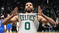 Boston Celtics forward Jayson Tatum (0) shows off his jersey before their game against the Oklahoma City Thunder at TD Garden.