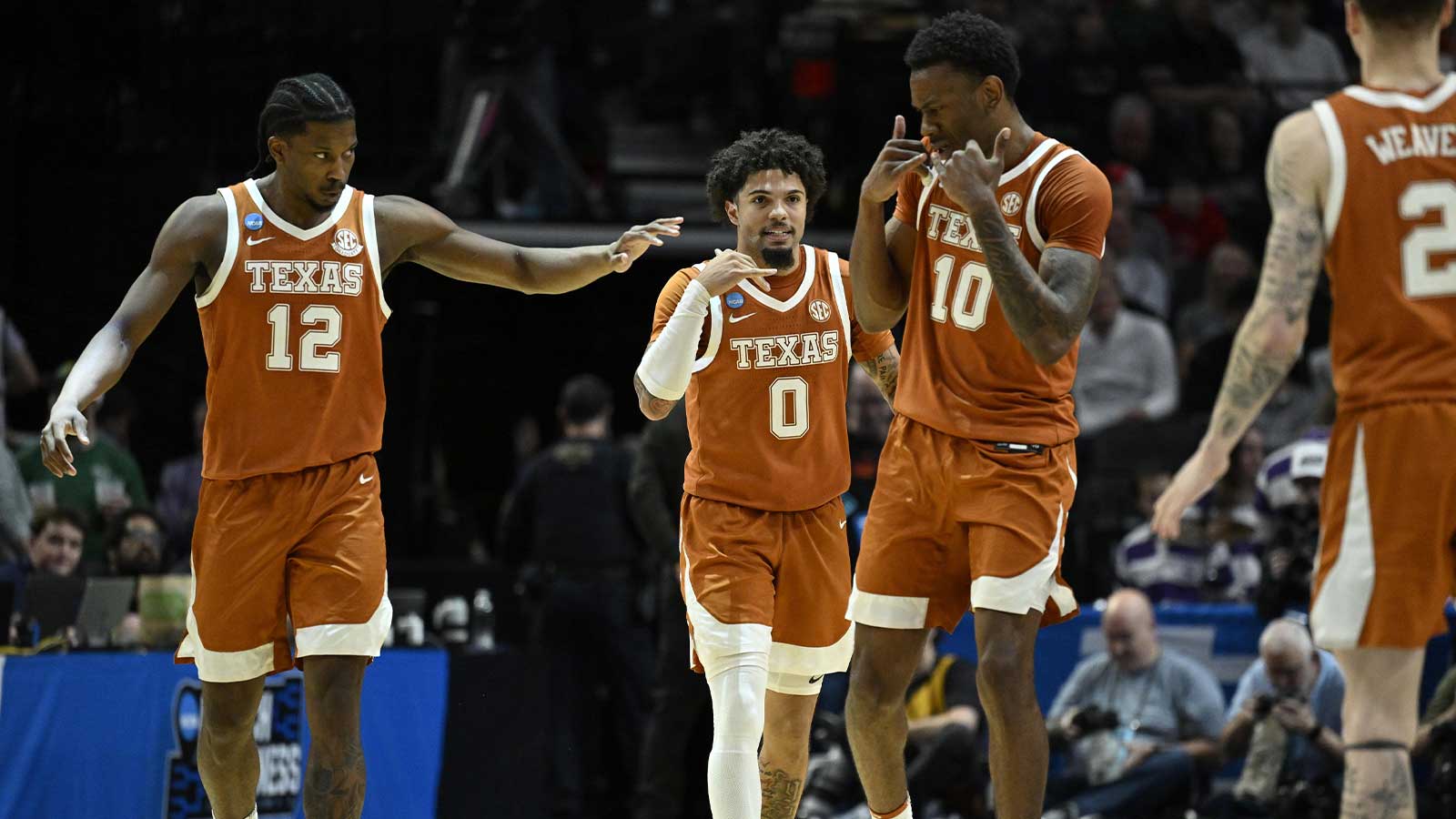 Texas Longhorns guard Tramon Mark (12), guard Jordan Pope (0) and forward Nic Codie (10) react after a play in the second half against the Gonzaga Bulldogs during a second round game of the men's 2026 NCAA Tournament at Moda Center.
