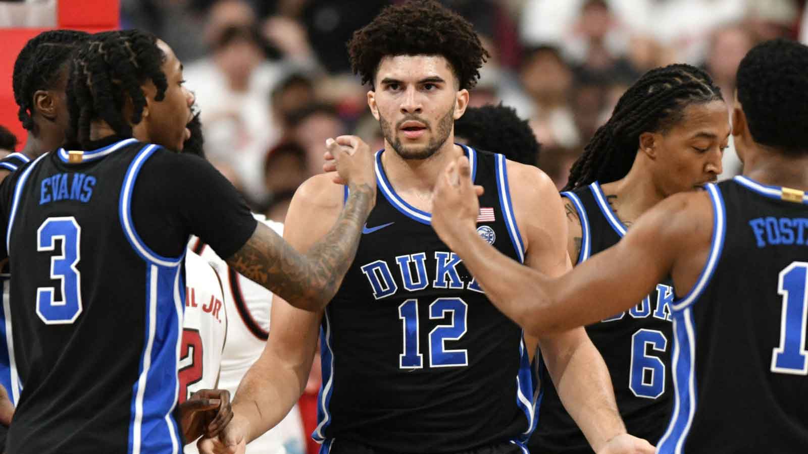 Duke Blue Devils forward Cameron Boozer (12) reacts with guard Isaiah Evans (3) and guard Caleb Foster (1) after being fouled during the first half against the NC State Wolfpack at Lenovo Center.