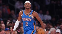 Thunder guard Shai Gilgeous-Alexander (2) dribbles up court against the New York Knicks during the first half at Madison Square Garden with Wilt Chamberlain in the background