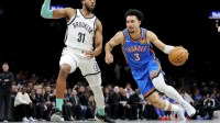 Thunder guard Jared McCain (3) drives to the basket against Brooklyn Nets forward Chaney Johnson (31) during the first quarter at Barclays Center with Thunder's Mark Daigneault in the background