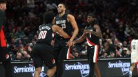 Portland Trail Blazers guard Scoot Henderson (00) hugs teammate forward Toumani Camara (33) after scoring against the Brooklyn Nets during the second half at Moda Center.
