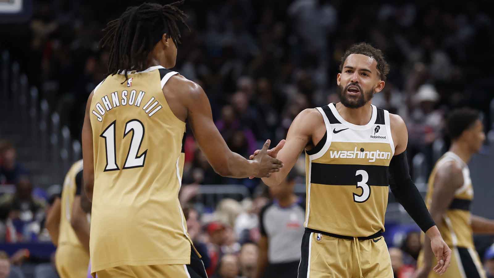 Washington Wizards guard Trae Young (3) celebrates with Wizards guard Tre Johnson (12) after a base against the Utah Jazz in the second half at Capital One Arena.