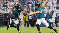 Jacksonville Jaguars quarterback Trevor Lawrence (16) hands the ball to Jacksonville Jaguars running back Travis Etienne Jr. (1) against the Indianapolis Colts during the second half at EverBank Stadium.