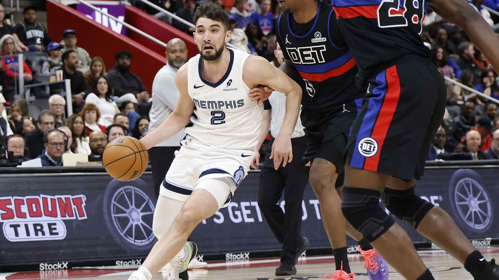 Memphis Grizzlies guard Ty Jerome (2) dribbles defended by Detroit Pistons forward Ronald Holland II (5) in the second half at Little Caesars Arena.