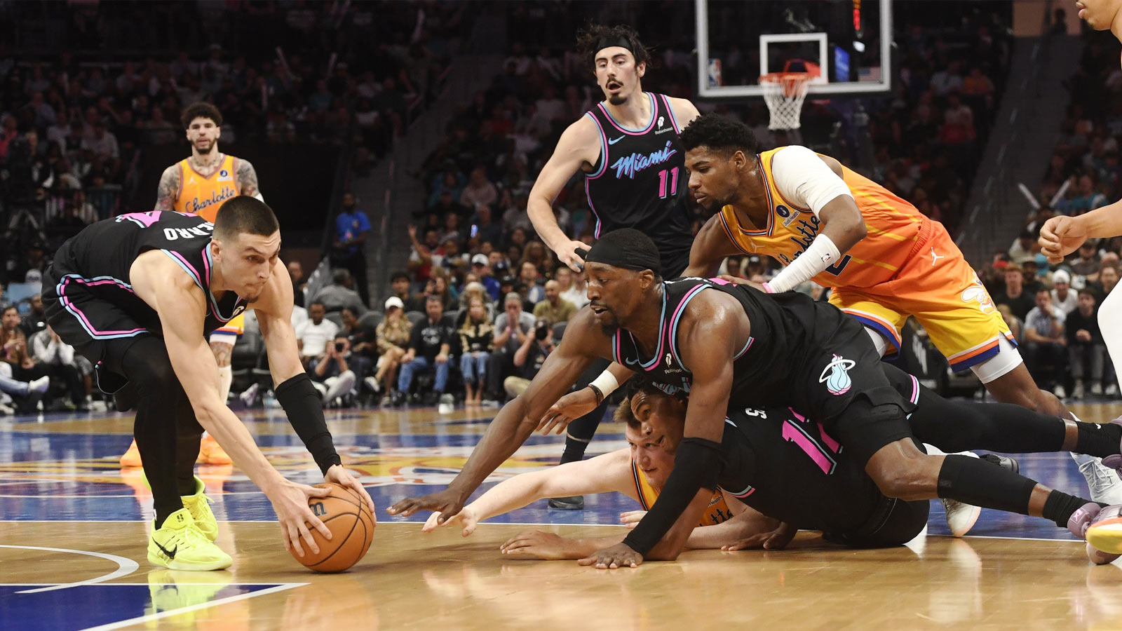 Miami Heat guard Tyler Herro (14) gets a loose ball from Charlotte Hornets forward Kon Knueppel (7), Miami Heat guard Dru Smith (12) and center forward Bam Adebayo (13) during the second half at the Spectrum Center.