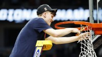 UConn Huskies guard Braylon Mullins (24) cuts down the net after defeating the Duke Blue Devils in an Elite Eight game of the East Regional of the men's 2026 NCAA Tournament at Capital One Arena.