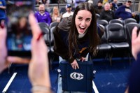 Indiana Fever guard Caitlin Clark reacts to her logo being on the back of her court chair before the game between the Indiana Pacers and the Los Angeles Lakers at Gainbridge Fieldhouse