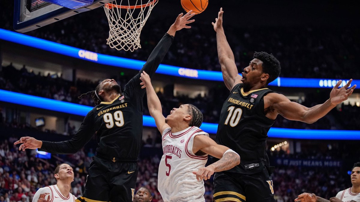 Vanderbilt forward Devin McGlockton (99), forward Ak Okereke (10) and Arkansas guard Darius Acuff Jr. (5) scramble for a rebound during the second half of the SEC tournament championship game at Bridgestone Arena in Nashville, Tenn., Sunday, March 15, 2026.