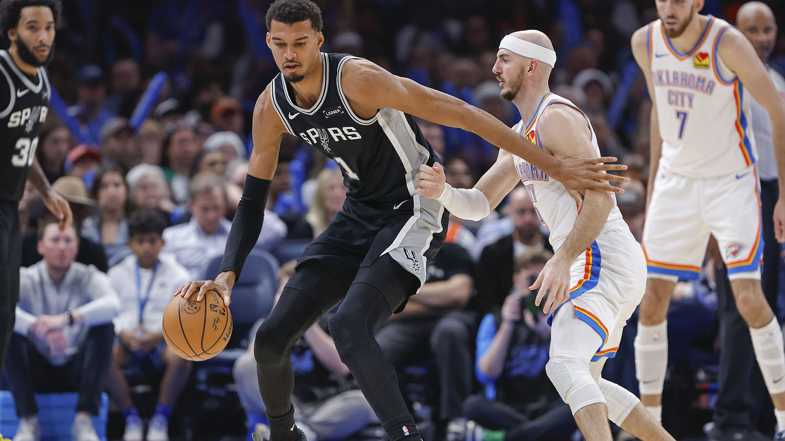 San Antonio Spurs forward Victor Wembanyama (1) moves the ball across the court against Oklahoma City Thunder guard Alex Caruso (9) during the second half at Paycom Center. 
