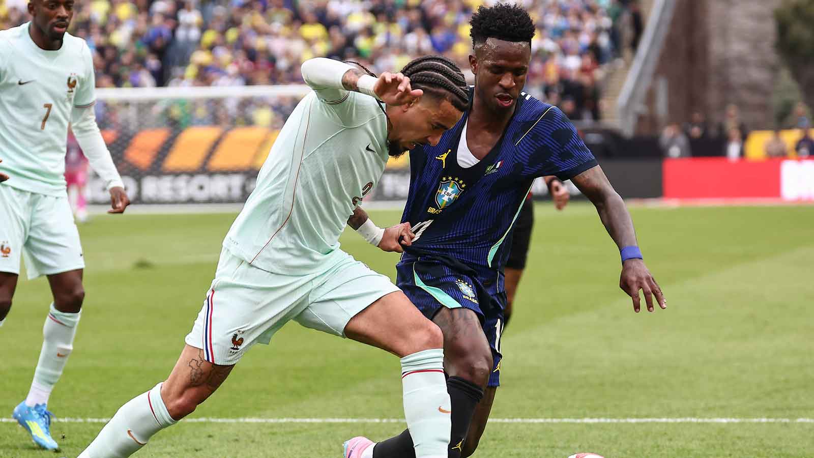 France defender Malo Gusto (2) tugs on the jersey of Brazil forward Vinicius Junior (10) during the first half at Gillette Stadium.