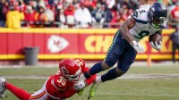 Seattle Seahawks running back Kenneth Walker III (9) runs the ball as Kansas City Chiefs cornerback Jaylen Watson (35) makes the tackle during the second half at GEHA Field at Arrowhead Stadium.