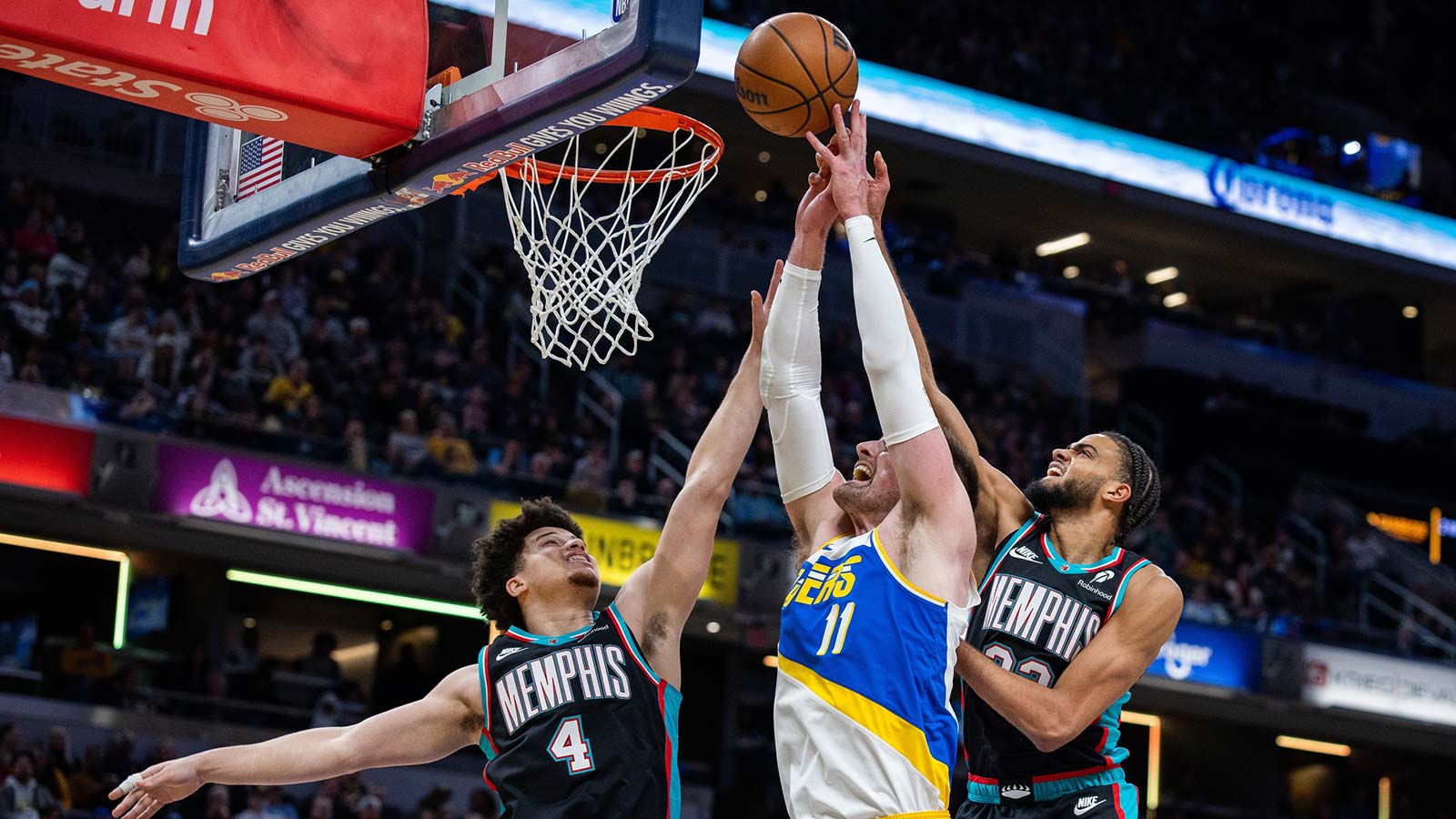 Indiana Pacers center Micah Potter (11) shoots the ball while Memphis Grizzlies guard Walter Clayton Jr. (4) and forward Taylor Hendricks (22) defend in the first half at Gainbridge Fieldhouse.