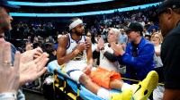 Golden State Warriors guard Moses Moody (4) waves to fans while leaving the court on a stretcher during overtime against the Dallas Mavericks at American Airlines Center.