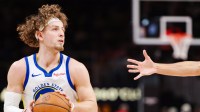 Warriors guard Brandin Podziemski (2) looks to shoot while being defended by Atlanta Hawks forward Zaccharie Risacher (10) in the third quarter at State Farm Arena with Warriors' Stephen Curry in the background