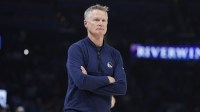 Warriors Head Coach Steve Kerr watches his team play against the Oklahoma City Thunder during the first half at Paycom Center with Thunder's Shai Gilgeous-Alexander in the background