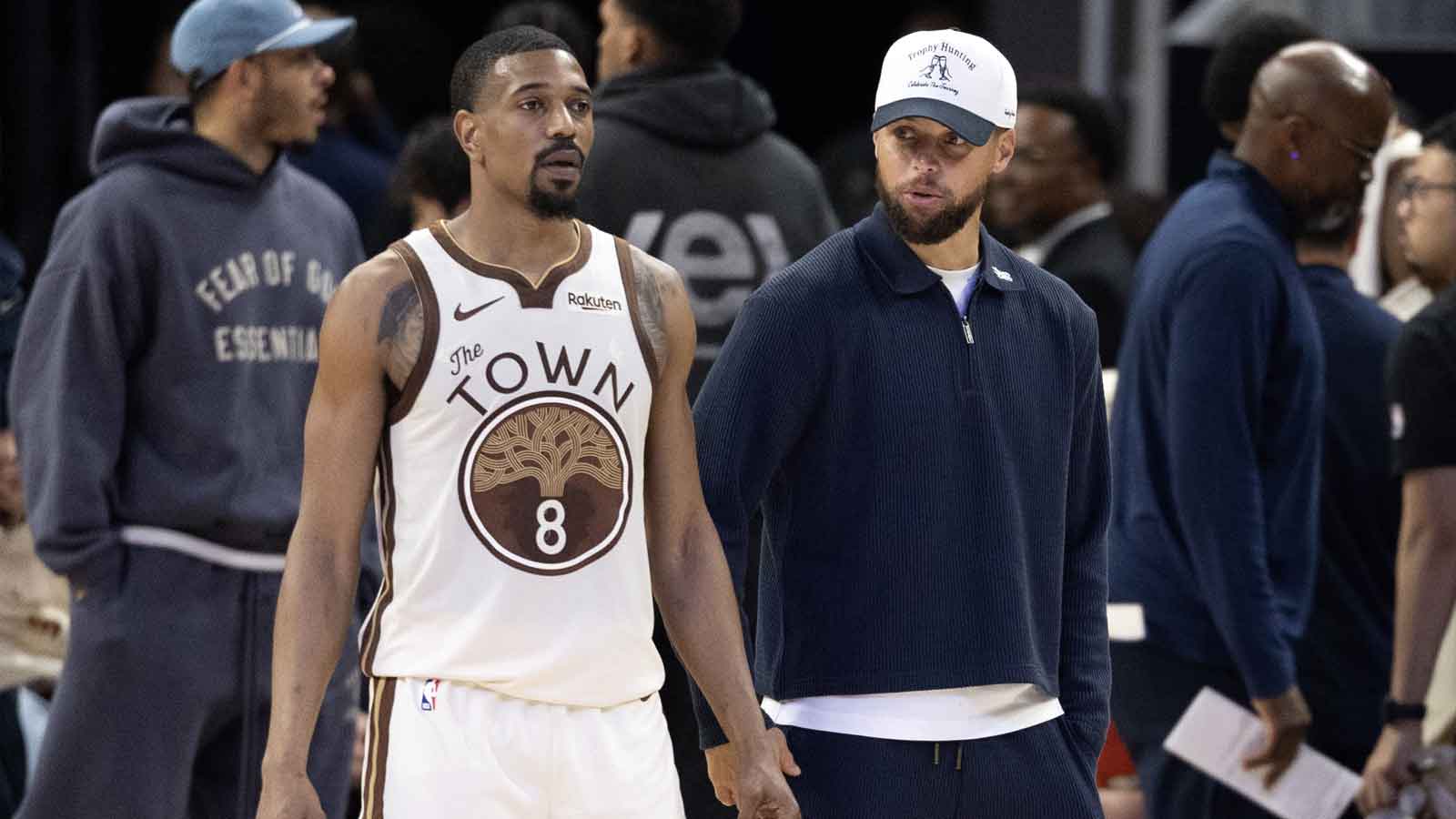Golden State Warriors guard De'Anthony Melton (8) talks with injured teammate Stephen Curry during the fourth quarter against the Los Angeles Clippers at Chase Center.