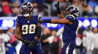 Los Angeles Chargers linebacker Odafe Oweh (98) and linebacker Daiyan Henley (0) react after a defensive play against the Houston Texans during the second half at SoFi Stadium.