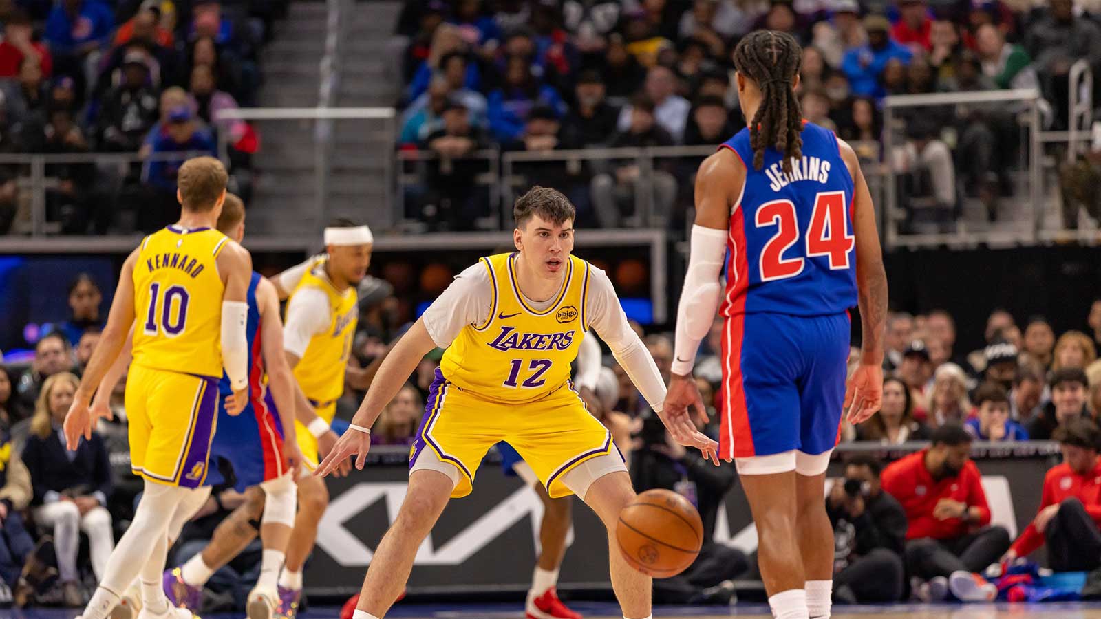Los Angeles Lakers Jake LaRavia (12) defends against Detroit Pistons Daniss Jenkins (24) during the first quarter at Little Caesars Arena.