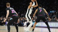 San Antonio Spurs forward Victor Wembanyama (1) takes a shot as Miami Heat center Kel'el Ware (7) and guard Kasparas Jakucionis (25) defend during the second half at Kaseya Center.