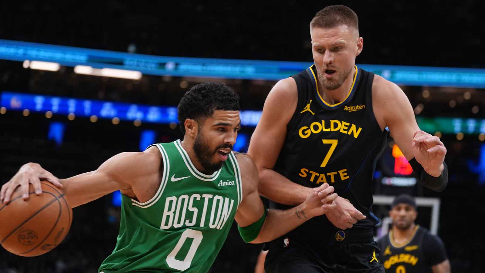 Boston Celtics forward Jayson Tatum (0) drives the ball against Golden State Warriors center Kristaps Porzingis (7) in the first quarter at TD Garden