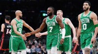 Boston Celtics guard Jaylen Brown (7), forward Jayson Tatum (0), guard Derrick White (9) and forward Sam Hauser (30) walk to the bench during a timeout against the Miami Heat in the second quarter during game two of the first round for the 2024 NBA playoffs at TD Garden.