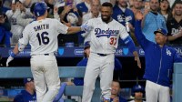 Los Angeles Dodgers catcher Will Smith (16) celebrates with right fielder Teoscar Hernandez (37) after hitting a two-run home run during the eighth inning against the Arizona Diamondbacks at Dodger Stadium.