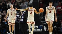 Wisconsin Badgers guard Andrew Rohde (7), guard Nick Boyd (2), and forward Nolan Winter (31) react during the second half of a first round game of the men's 2026 NCAA Tournament against the High Point Panthers at Moda Center.