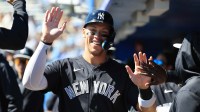 New York Yankees right fielder Aaron Judge (99) smiles as he high fives in the dugout after he scored a run during the first inning against the Toronto Blue Jays at TD Ballpark.