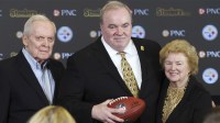 Joe McCarthy Jr. (left) and Ellen McCarthy (right) flank their son Mike McCarthy (middle) at a press conference announcing Mike as the new Pittsburgh Steelers head coach at PNC Champions Club at Acrisure Stadium.