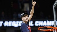 UConn Huskies guard Braylon Mullins (24) cuts down the net after defeating the Duke Blue Devils in an Elite Eight game of the East Regional of the men's 2026 NCAA Tournament at Capital One Arena.