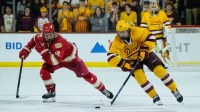 Sam Harris (12) of the Denver Pioneers follows Cruz Lucius (51) of the Arizona State Sun Devils down the ice as they play 3-on-3 in overtime at Mullett Arena on Feb. 8, 2025, in Tempe, Ariz.