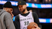 Golden State Warriors guard Stephen Curry (30) talks with guard Gary Payton II (0) during a timeout against the San Antonio Spurs in the fourth quarter at the Chase Center.