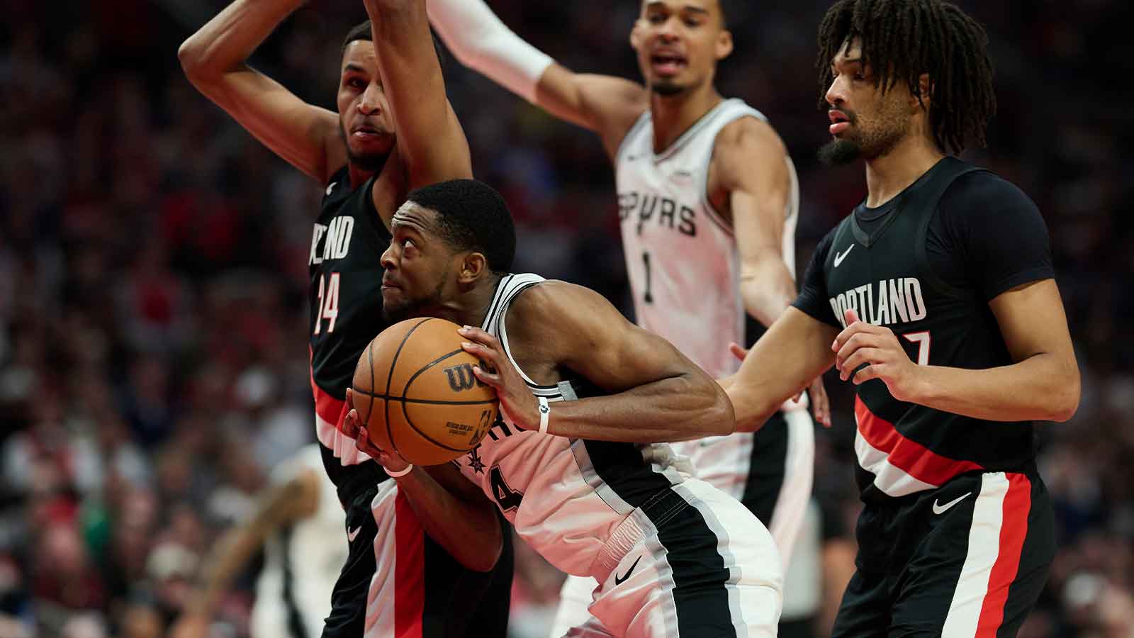 Apr 26, 2026; Portland, Oregon, USA; San Antonio Spurs guard De'aaron Fox (4) drives to the basket during the second half against Portland Trail Blazers forward Kris Murray (24) and guard Shaedon Sharpe (17) during game four of the first round of the 2026 NBA Playoffs at Moda Center.