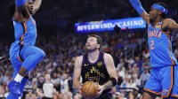 ; Los Angeles Lakers guard Luka Doncic (77) drives between Oklahoma City Thunder guard Luguentz Dort (5) and guard Shai Gilgeous-Alexander (2) during the first quarter at Paycom Center.