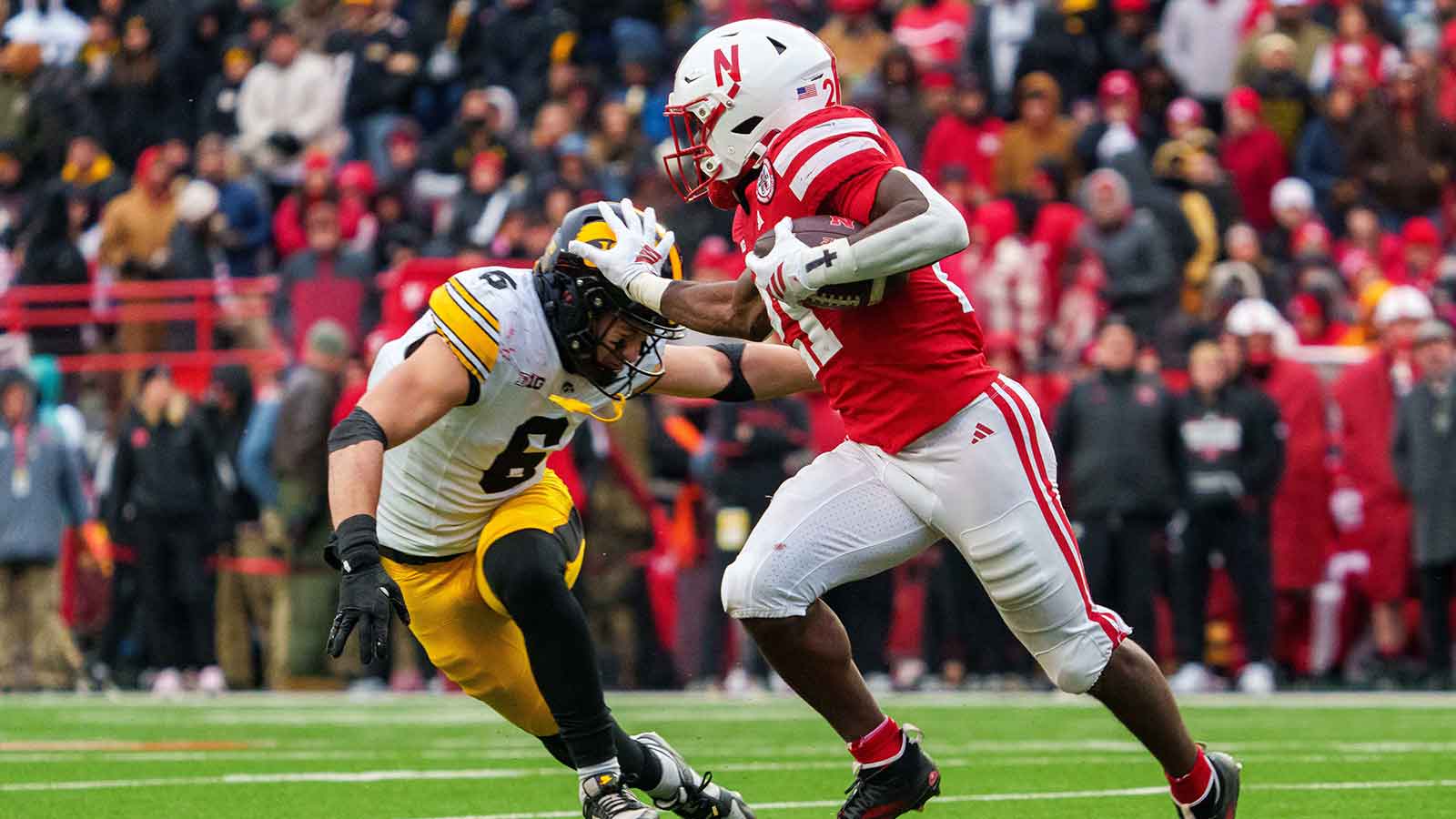 Nebraska Cornhuskers running back Emmett Johnson (21) runs against Iowa Hawkeyes defensive back Zach Lutmer (6) during the third quarter at Memorial Stadium.
