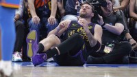 Los Angeles Lakers guard Luka Doncic (77) falls to the court during a play against the Oklahoma City Thunder during the third quarter at Paycom Center.