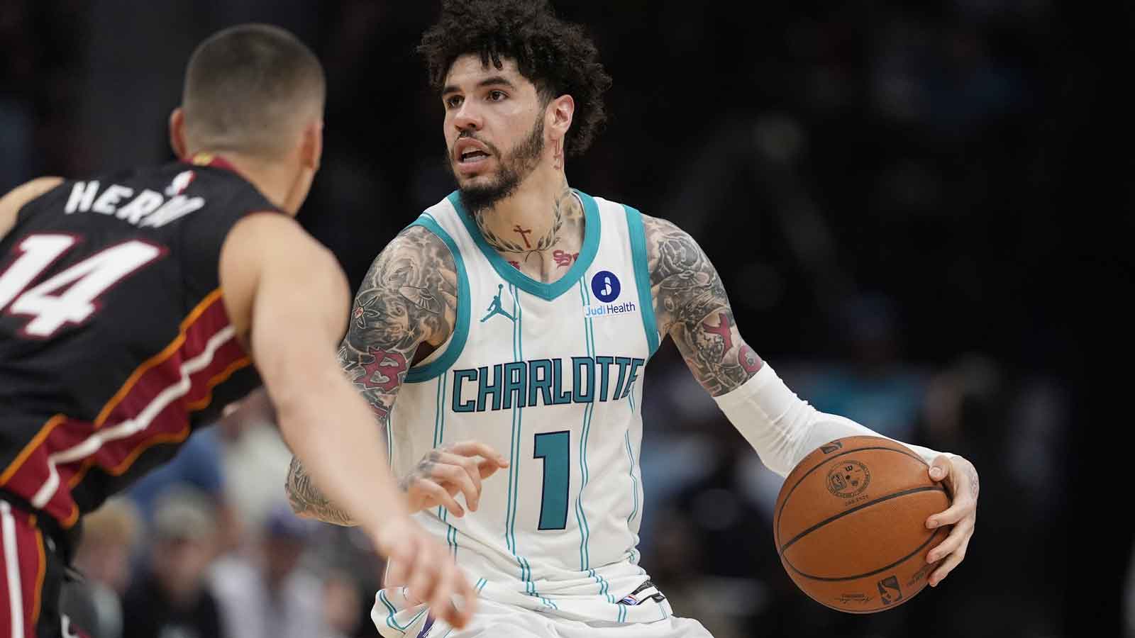 Hornets guard LaMelo Ball (1) looks to pass defended by Miami Heat guard Tyler Herro (14) during the second half during the play-in rounds between the Charlotte Hornets and the Miami Heat of the 2026 NBA Playoffs at Spectrum Center
