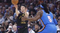 Los Angeles Lakers guard Austin Reaves (15) passes around Oklahoma City Thunder guard Luguentz Dort (5) during the first quarter at Paycom Center.