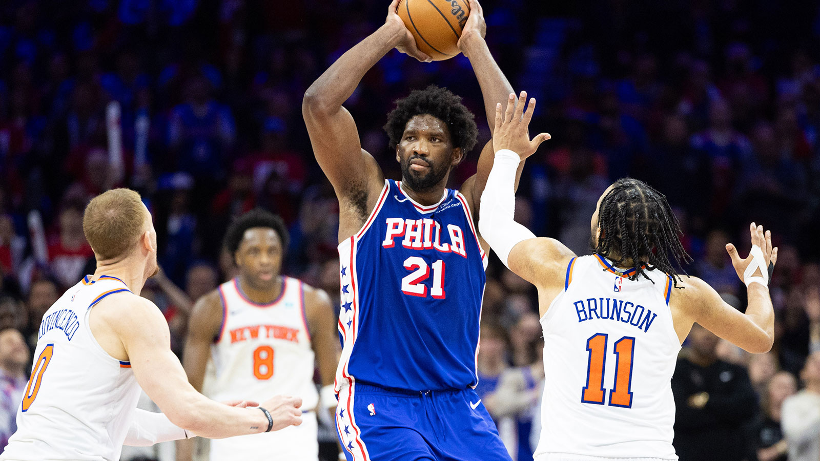 Philadelphia 76ers center Joel Embiid (21) controls the ball in front of New York Knicks guard Jalen Brunson (11) and guard Donte DiVincenzo (0) during the second half of game three of the first round for the 2024 NBA playoffs at Wells Fargo Center.