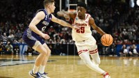 Wisconsin Badgers guard John Blackwell (25) drives against High Point Panthers guard Conrad Martinez (9) during the second half of a first round game of the men's 2026 NCAA Tournament at Moda Center.