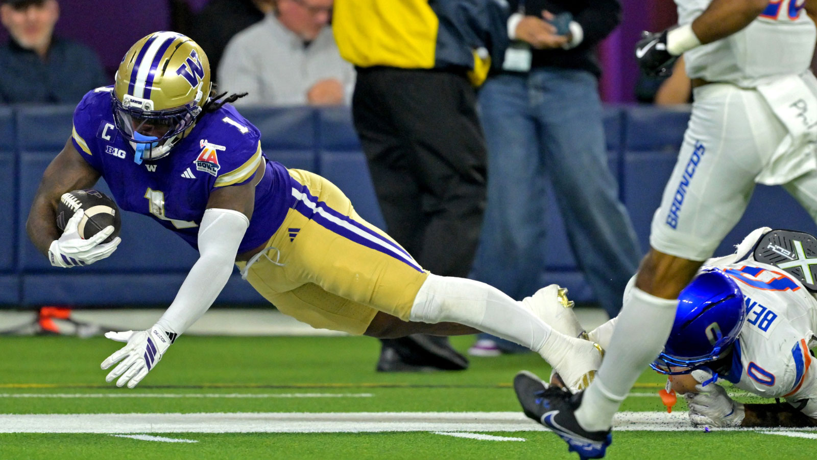 Washington Huskies running back Jonah Coleman (1) is stopped short of the goal line by Boise State Broncos defensive back Ty Benefield (0) in the first half of the LA Bowl at SoFi Stadium. 