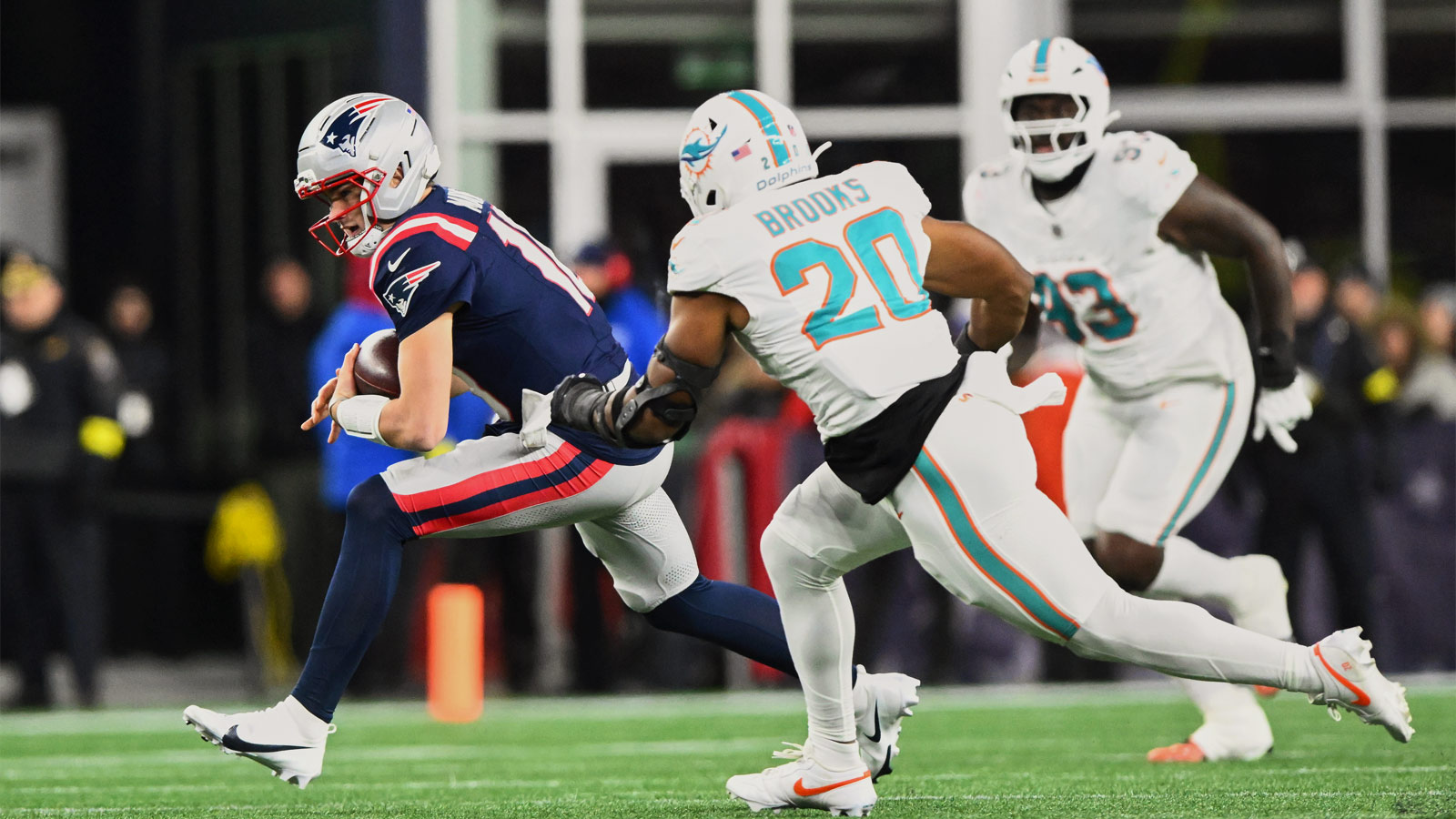 New England Patriots quarterback Drake Maye (10) scrambles against Miami Dolphins linebacker Jordyn Brooks (20) during the second quarter at Gillette Stadium.