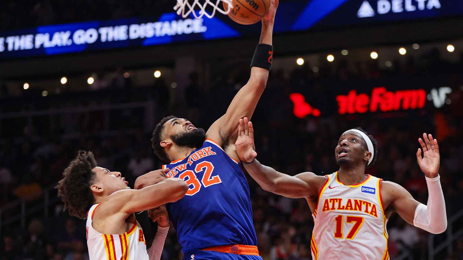 Apr 30, 2026; Atlanta, Georgia, USA; New York Knicks center Karl-Anthony Towns (32) grabs a rebound past Atlanta Hawks forward Jalen Johnson (1) and forward Onyeka Okongwu (17) in the second quarter during game six of the first round of the 2026 NBA Playoffs at State Farm Arena.