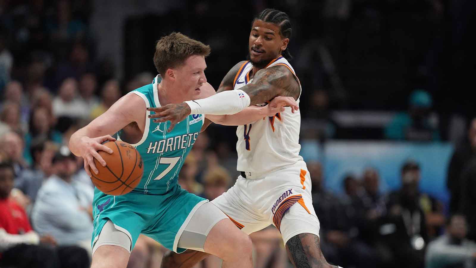 Charlotte Hornets guard/forward Kon Knueppel (7) moves the ball defended by Phoenix Suns guard Jalen Green (4) during the first quarter at Spectrum Center.