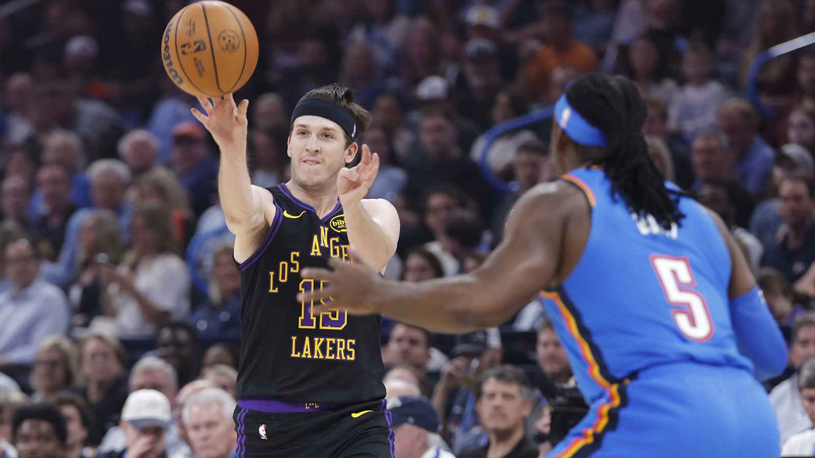 Lakers guard Austin Reaves (15) passes around Oklahoma City Thunder guard Luguentz Dort (5) during the first quarter at Paycom Center