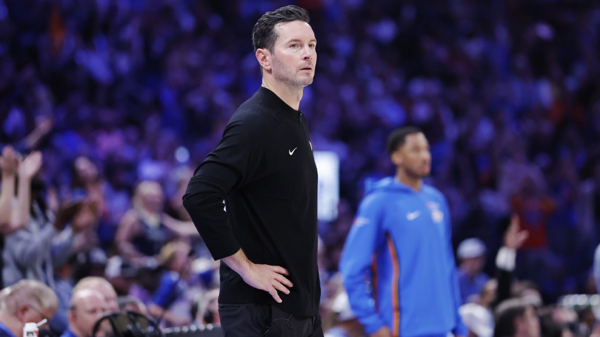 Lakers head coach JJ Redick watches his team play against the Oklahoma City Thunder during the second half at Paycom Center with Fox Sports 1's Colin Cowherd in the background